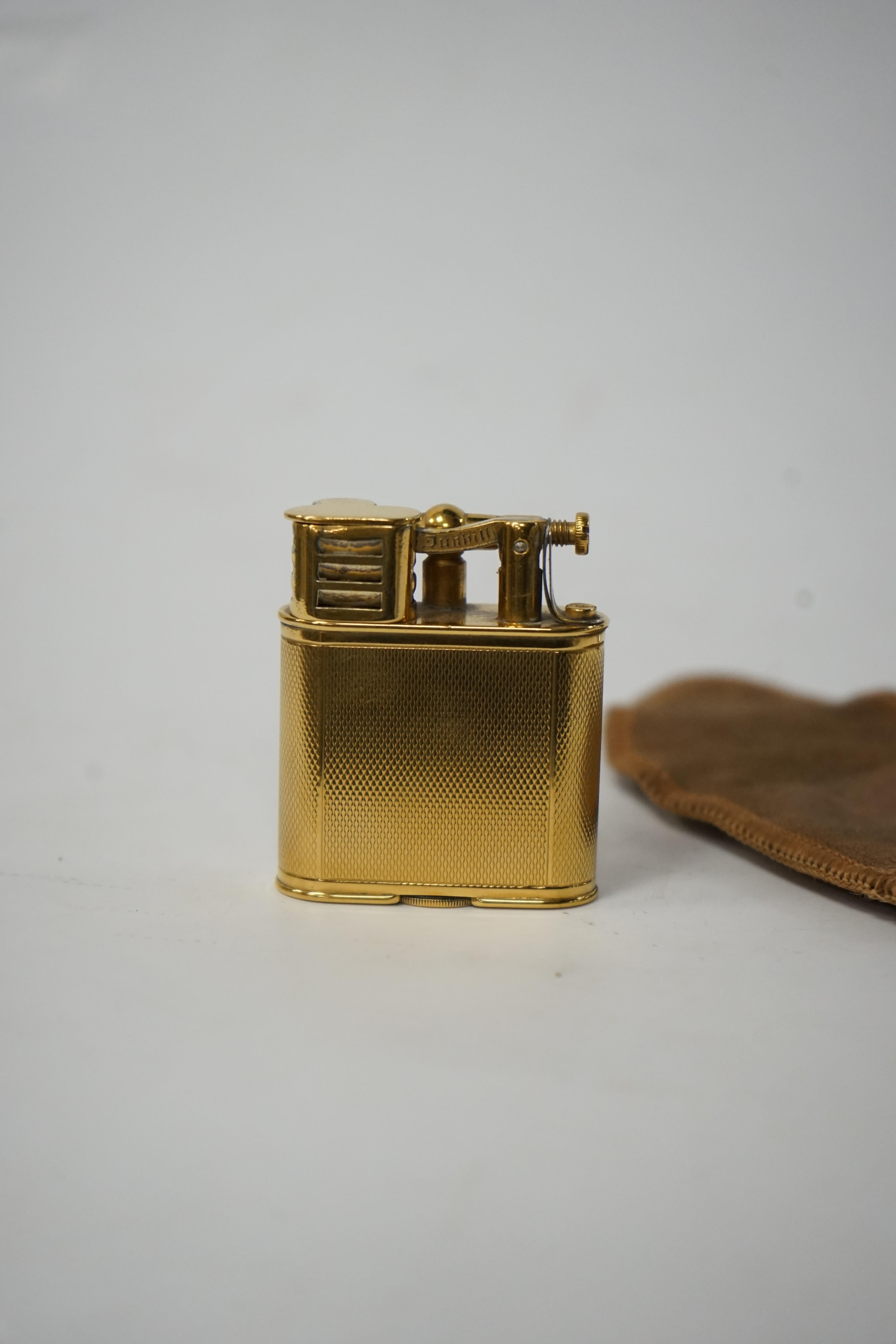 Two Dunhill lighters to include a plated table lighter, largest 10cm high. Condition - fair to good, not working